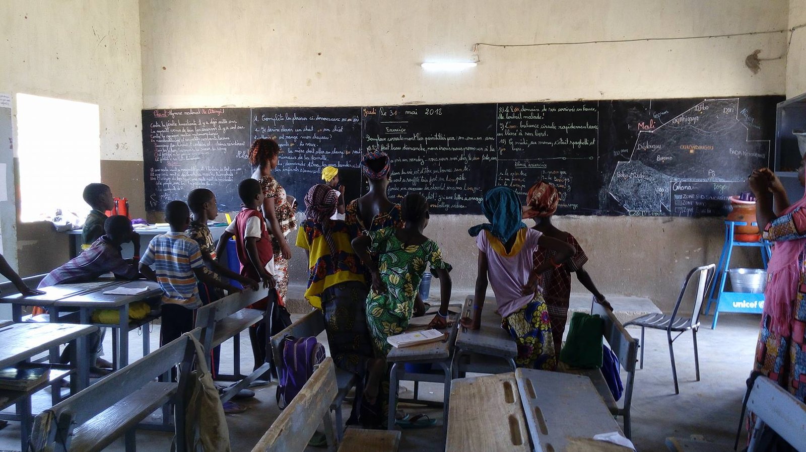 Students in a classroom lit by solar-powered lighting