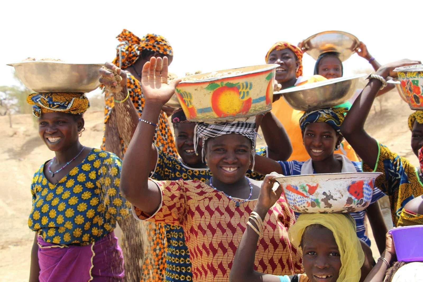 Women and girls carrying harvest